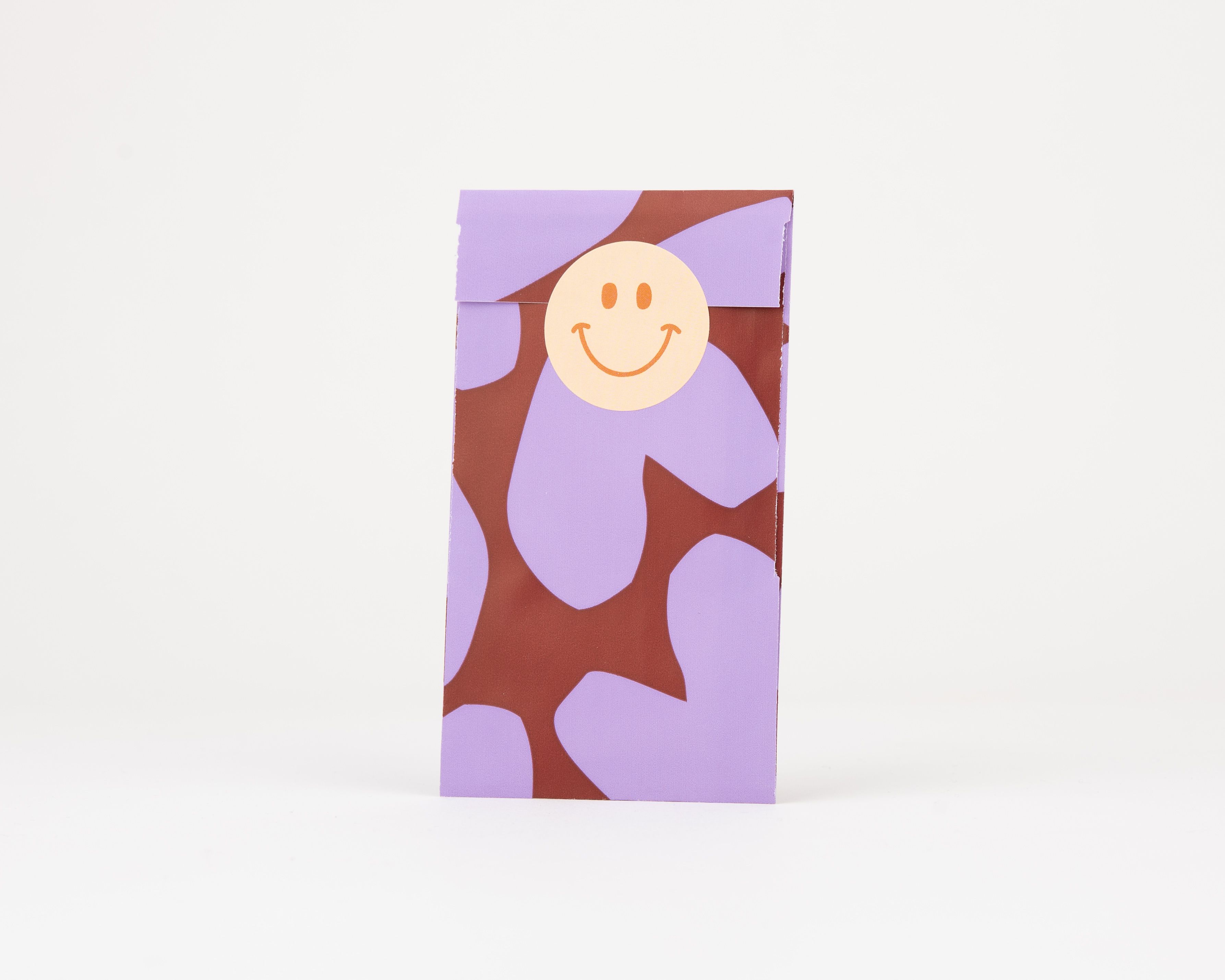 Papiertüten Flachbeutel mit lila und burgunderroten Herzformen, innen ebenfalls gemustert, und einem lächelnden Smiley Sticker