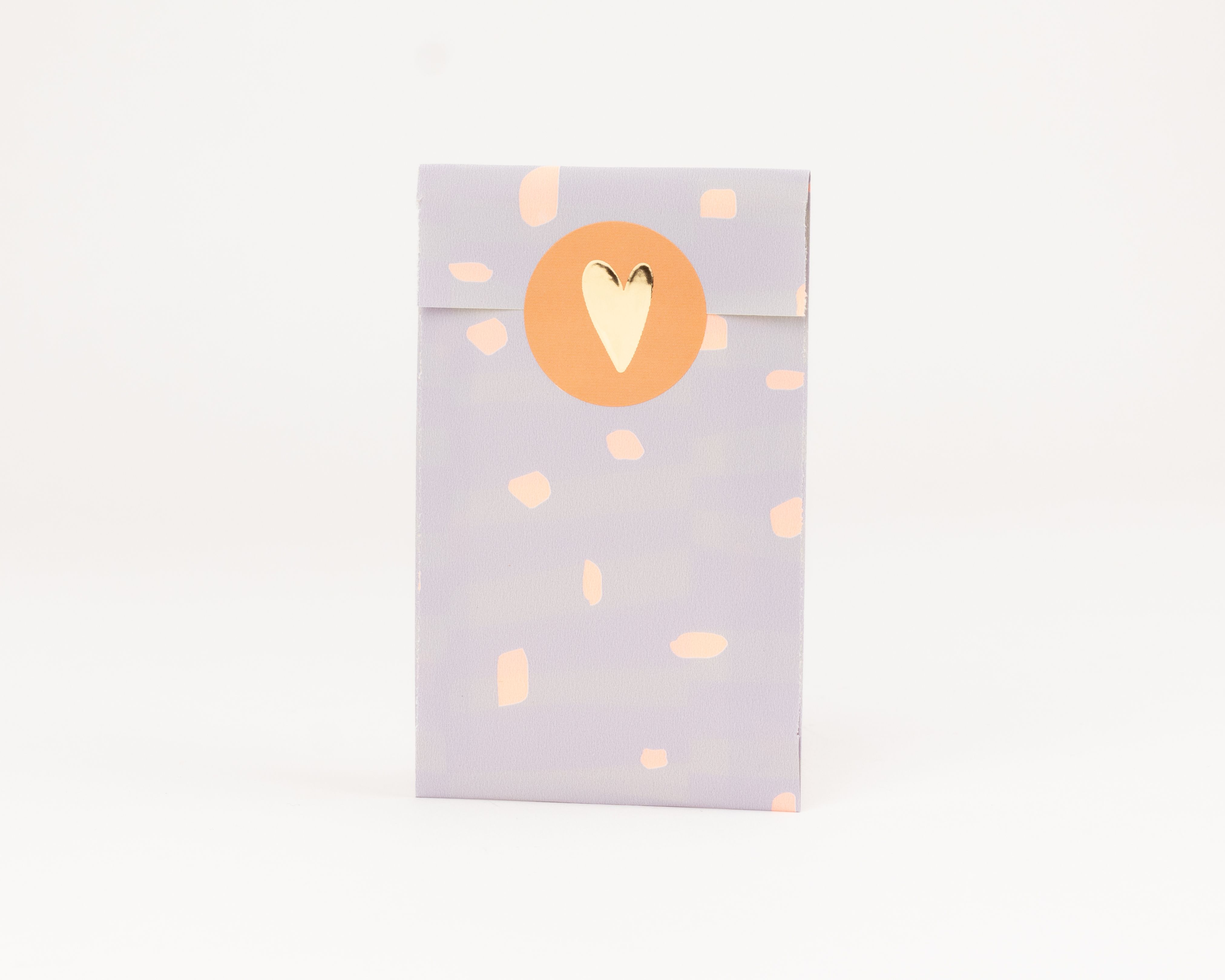 Flachbeutel in Fliederfarbe mit orangefarbenem Fleckenmuster außen, die Innenseite ist orange und ein runder Sticker mit goldenem Herz