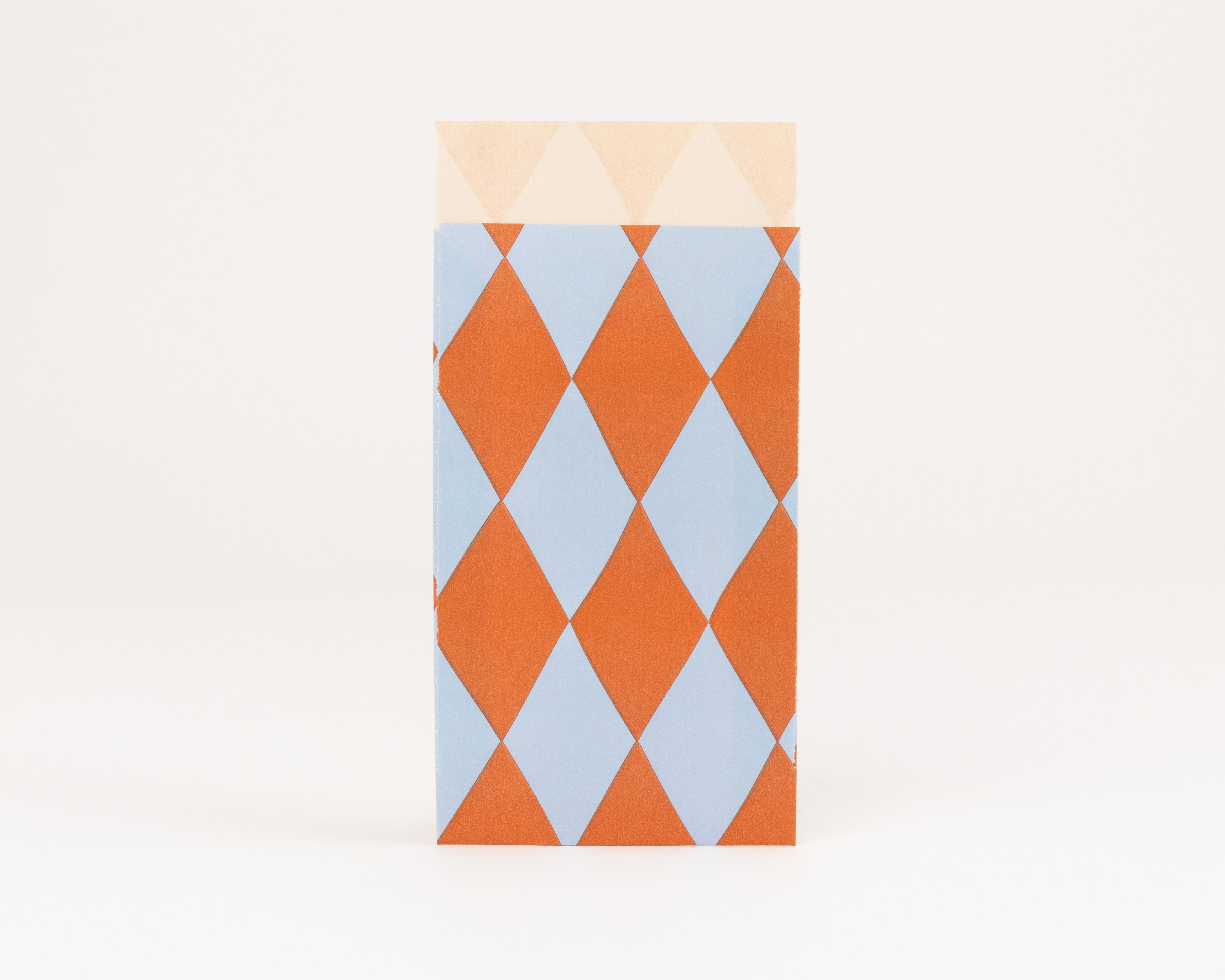 Flachbeutel mit auffälligem Rautenmuster in den Farben Blau und Orange. Die Innenseite zeigt ein dezentes Rautenmuster in hellem Beige