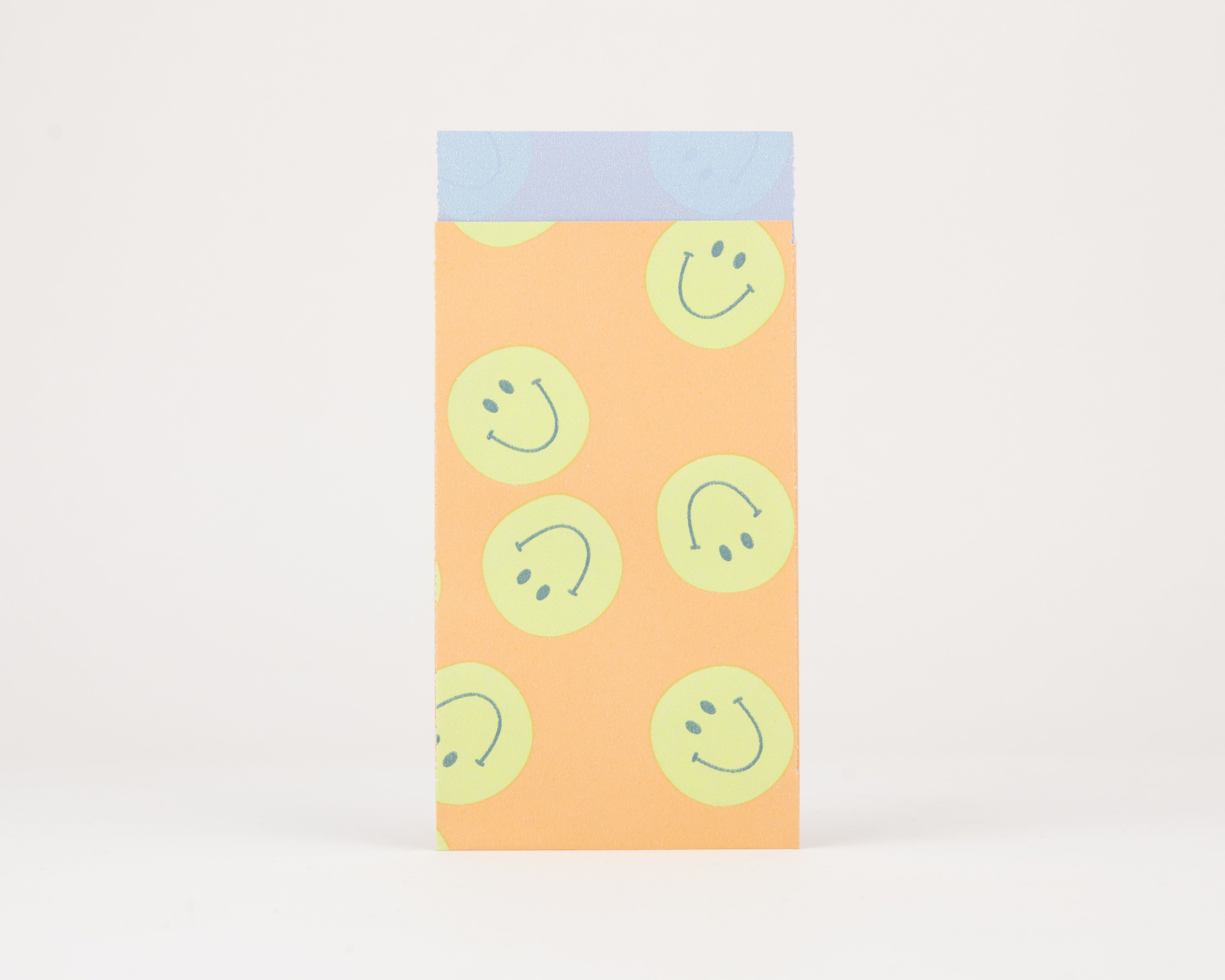 Papiertüten Flachbeutel mit orangefarbenem Hintergrund und grünen Smiley-Motiven. Die Innenseite zeigt eine blaue Farbe