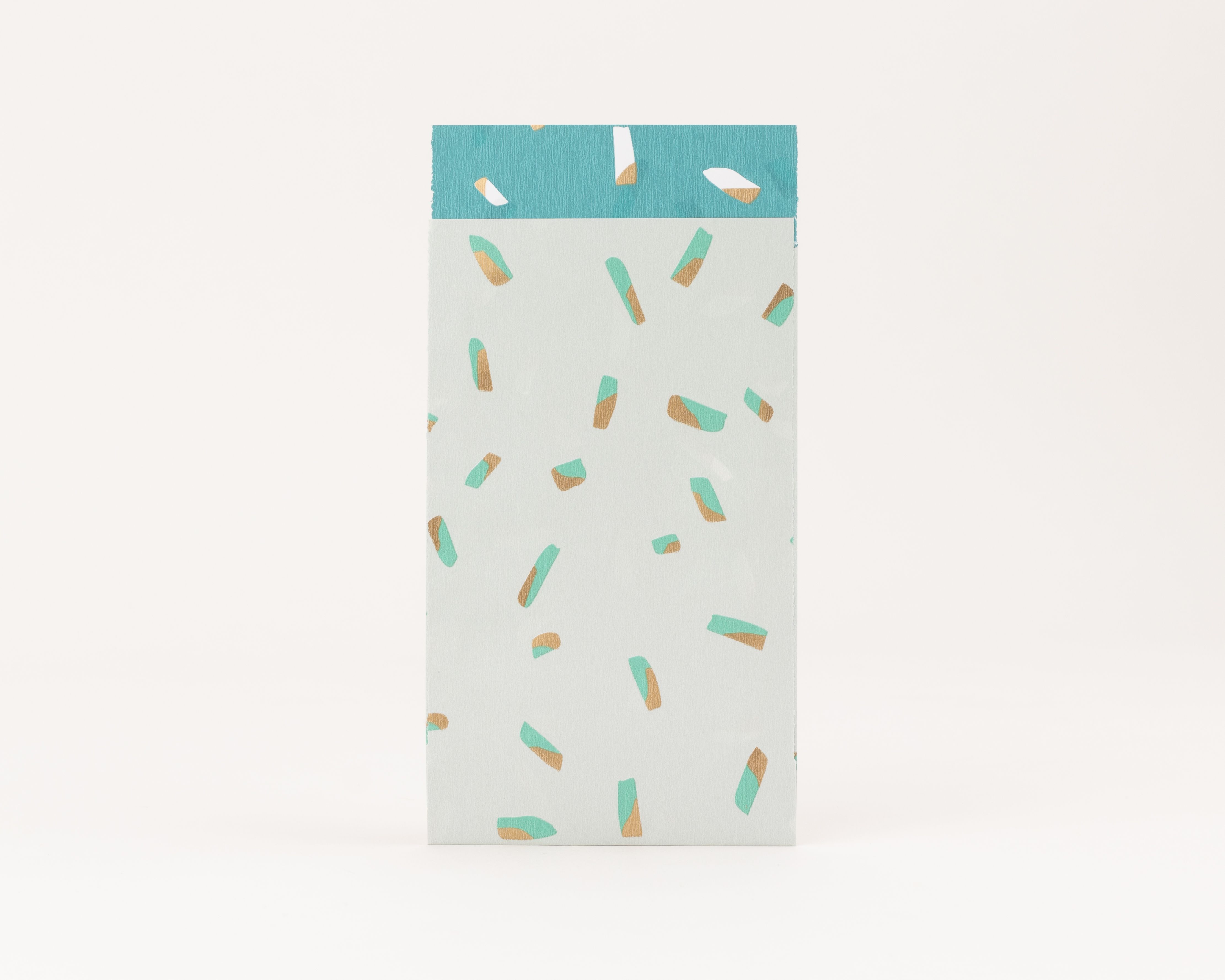 Flachbeutel in Salbeigrün mit türkisfarbenen und goldglänzenden Sprinkles-Muster. Die Innenseite ist Türkis mit goldenen Details