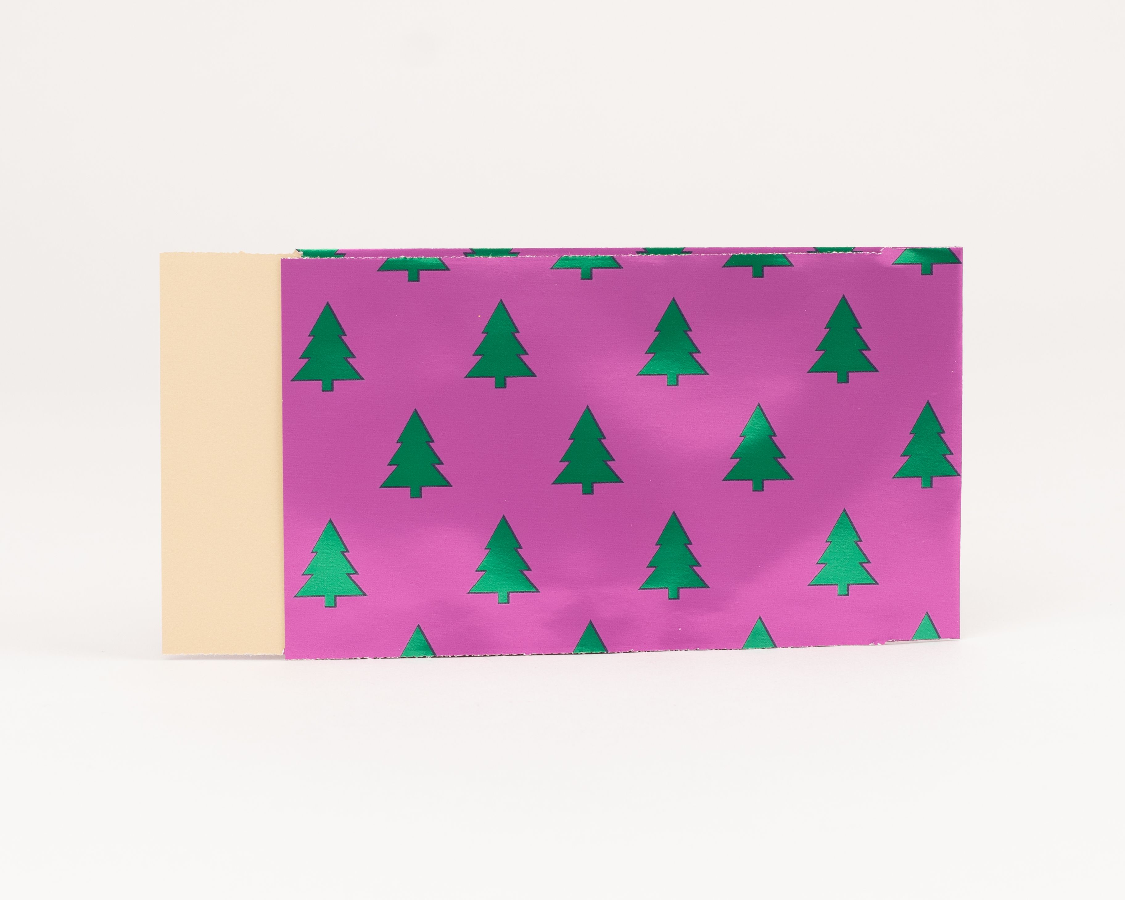 Flachbeutel mit einem Muster aus grünen Tannen auf pinkfarbenem Hintergrund und beigefarbener Innenseite