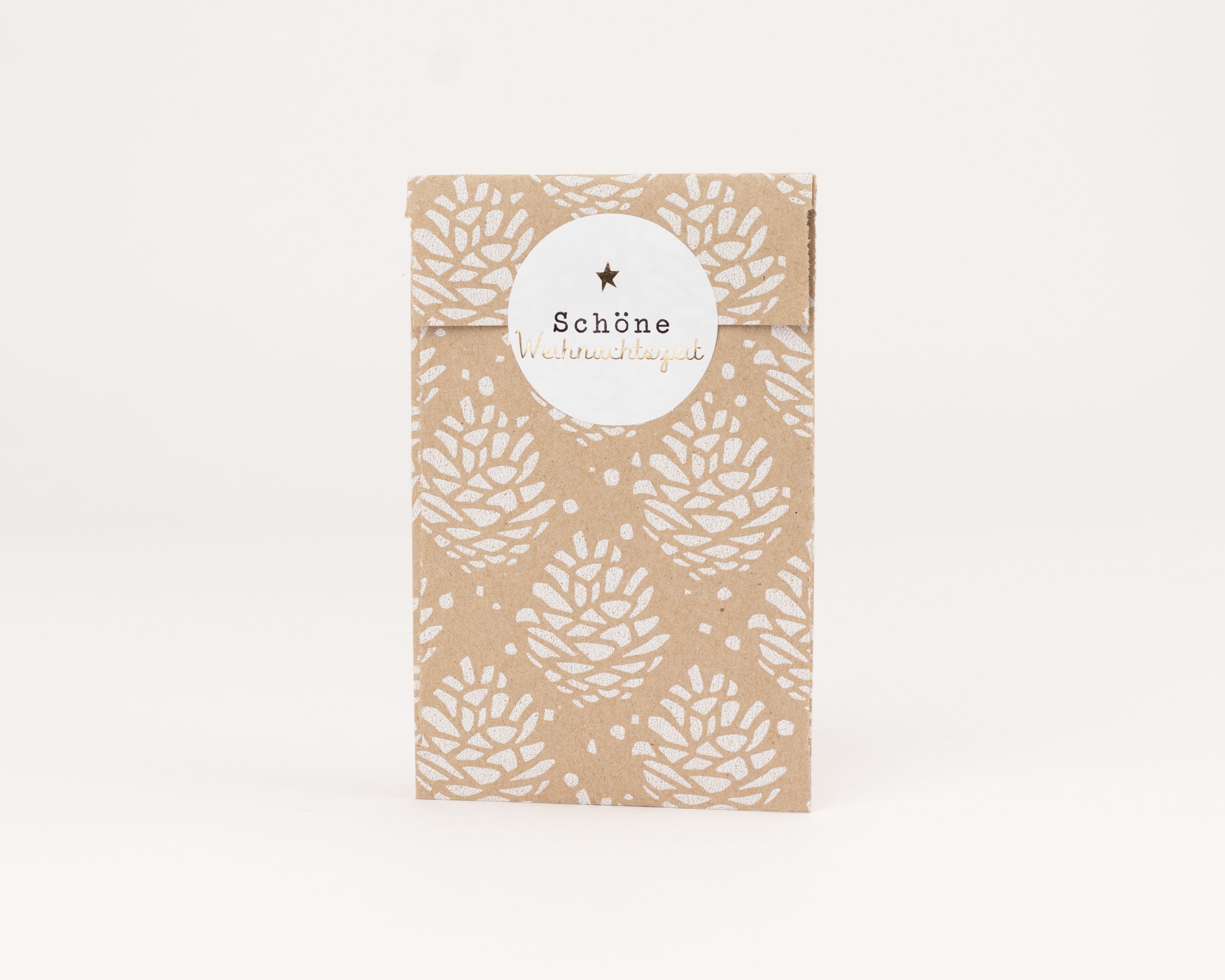 Flachbeutel mit brauner Außenseite und weißem Tannenzapfenmuster, die Innenseite ist weiß. Ein runder weißer Aufkleber verschließt die Papiertüten