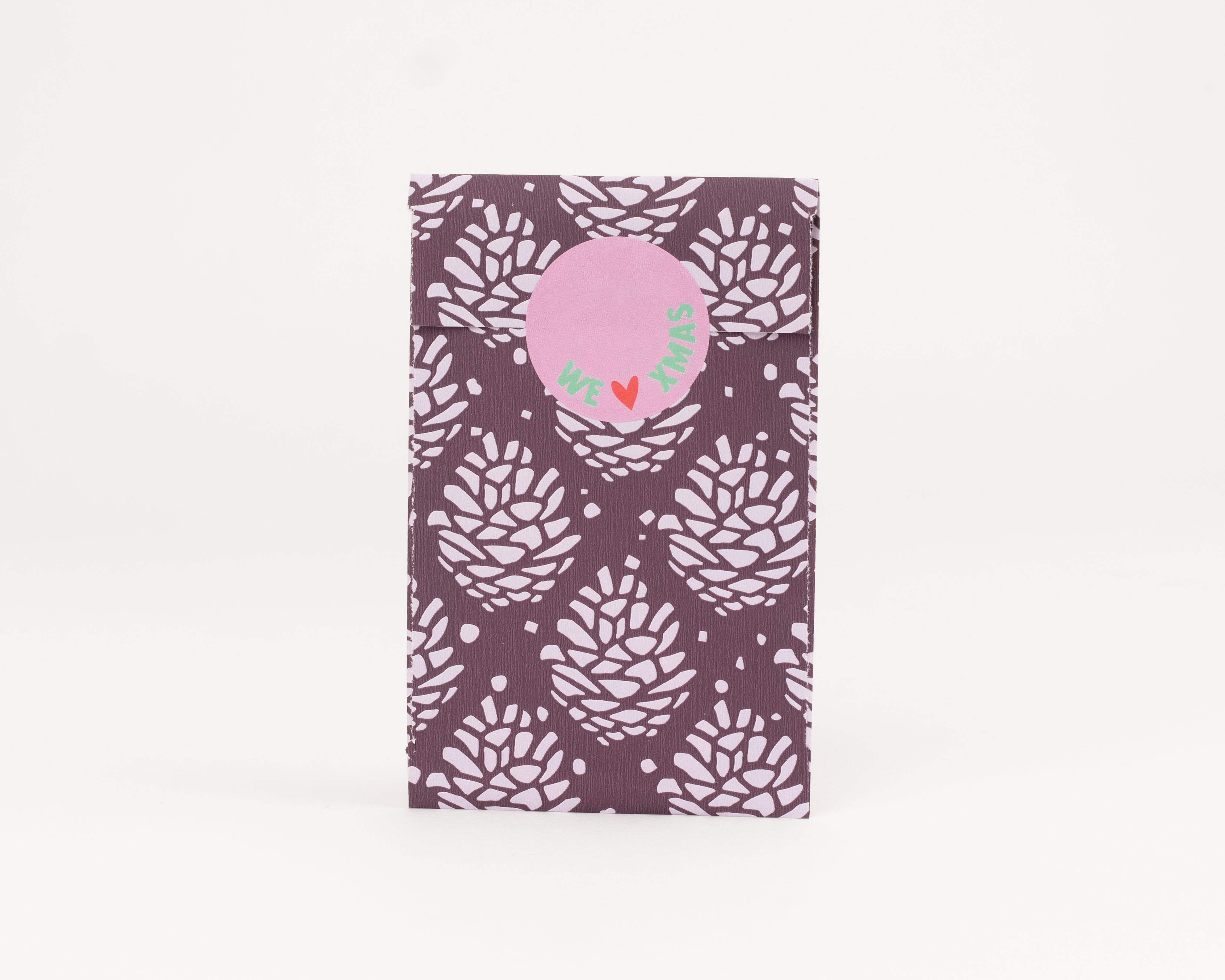 Flachbeutel mit dunkelviolettem Papier und einem stilisierten Tannenzapfenmuster in Hellviolett. Die Innenseite des Beutels ist einfarbig Hellviolett