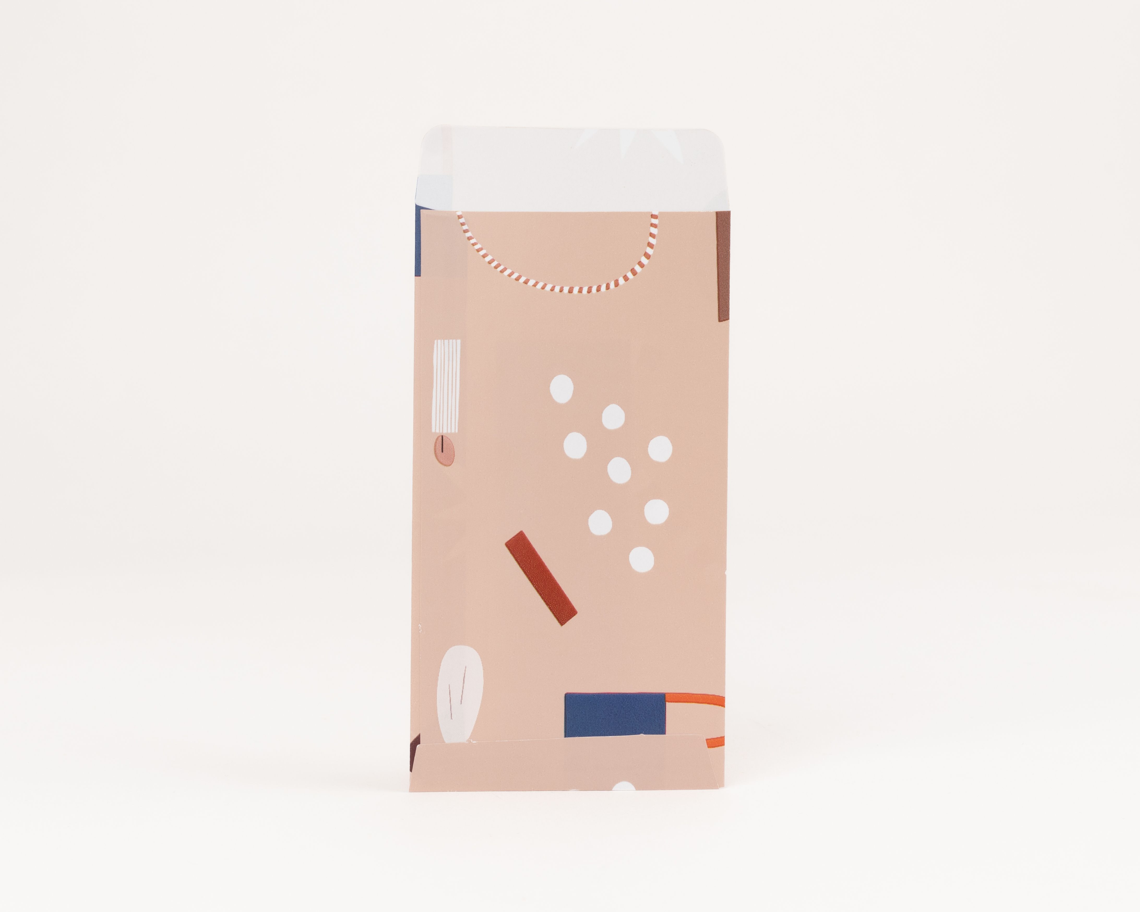 Flachbeutel mit beigefarbener Außenseite, verziert mit einem abstraktem Muster aus weißen Punkten und bunten Formen. Die Innenseite ist weiß mit Sternen