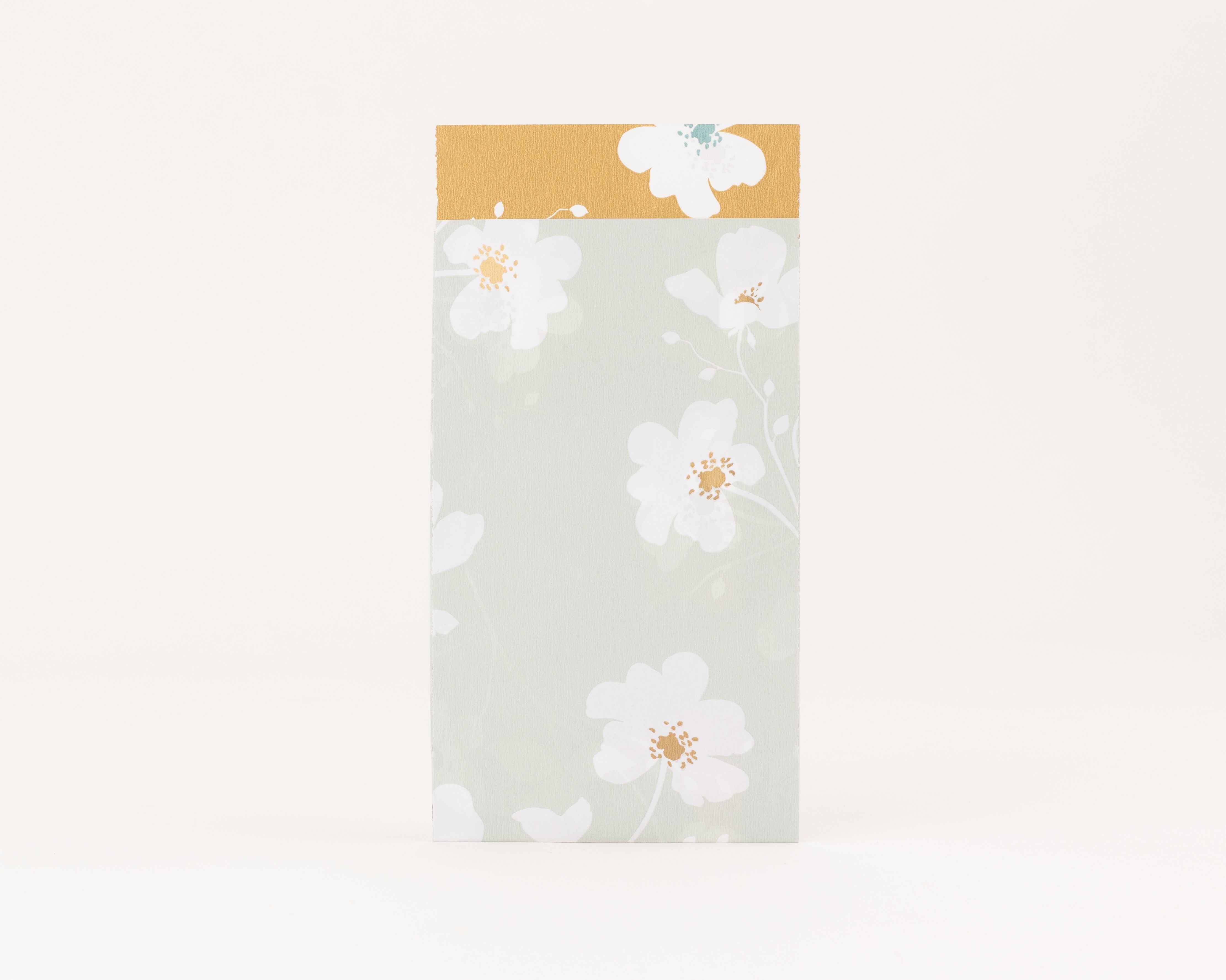 Flachbeutel in Salbeigrün mit weißem Wiesenblütenmuster und Goldeffekt auf den Blüten, die Innenseite zeigt das gleiche Design auf ockerfarbenem Hintergrund