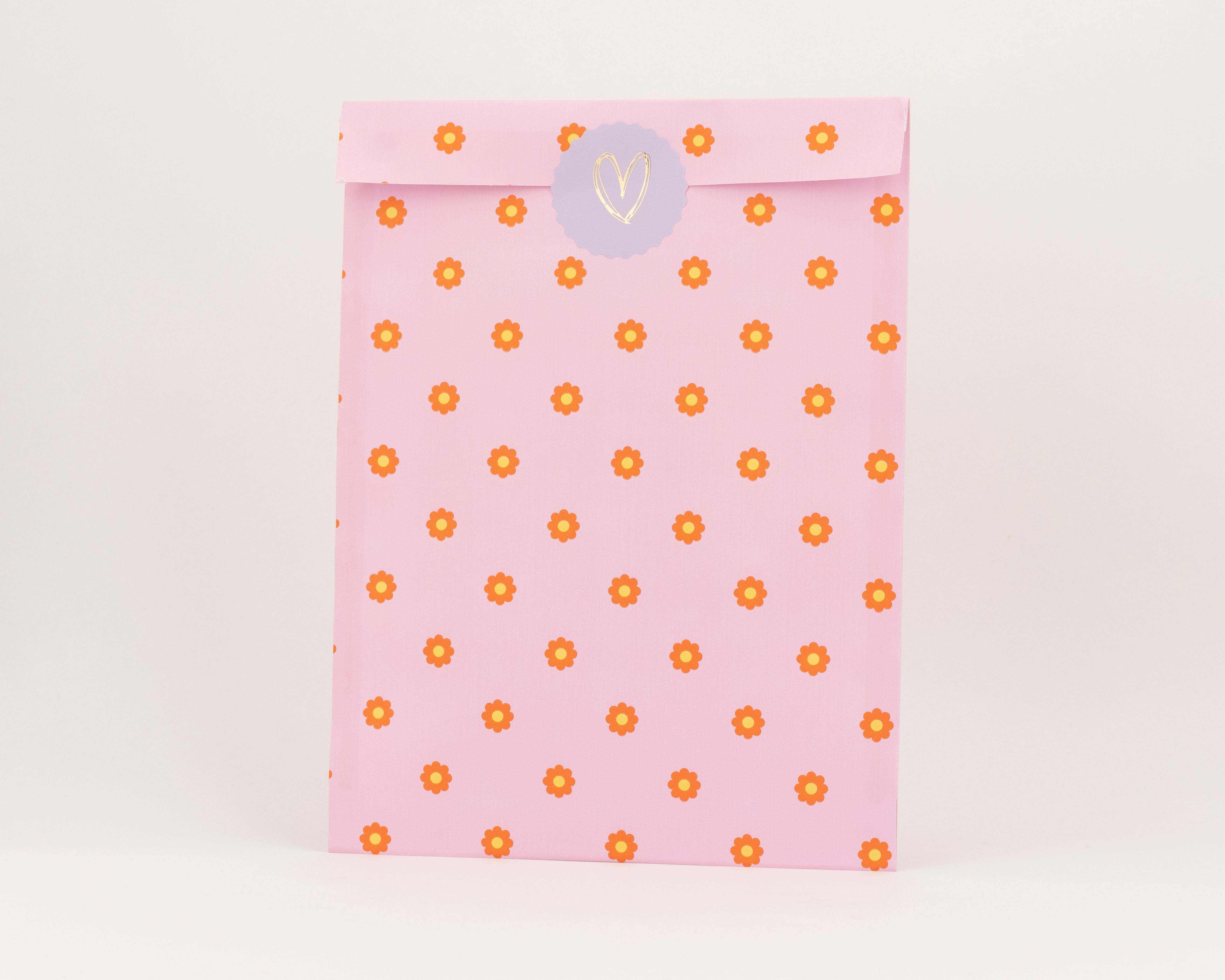 Flachbeutel in Pink mit einem durchgängigen Muster aus orangefarbenen Blumen und gelben Blütenmitten.