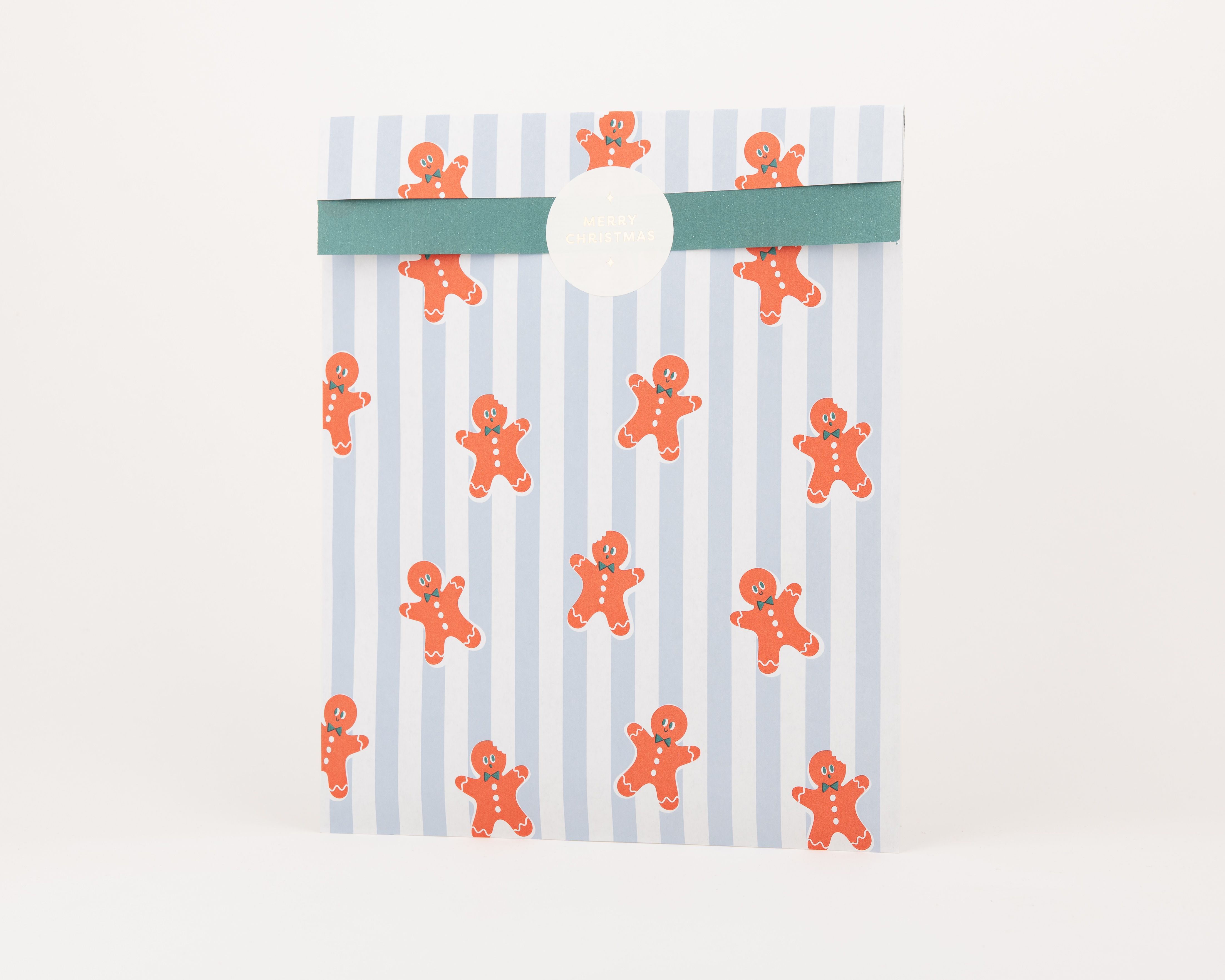 Papiertüten Flachbeutel zeigen ein Muster aus blauen Streifen und orangefarbenen Lebkuchenmännchen, die Innenseite ist einfarbig grün