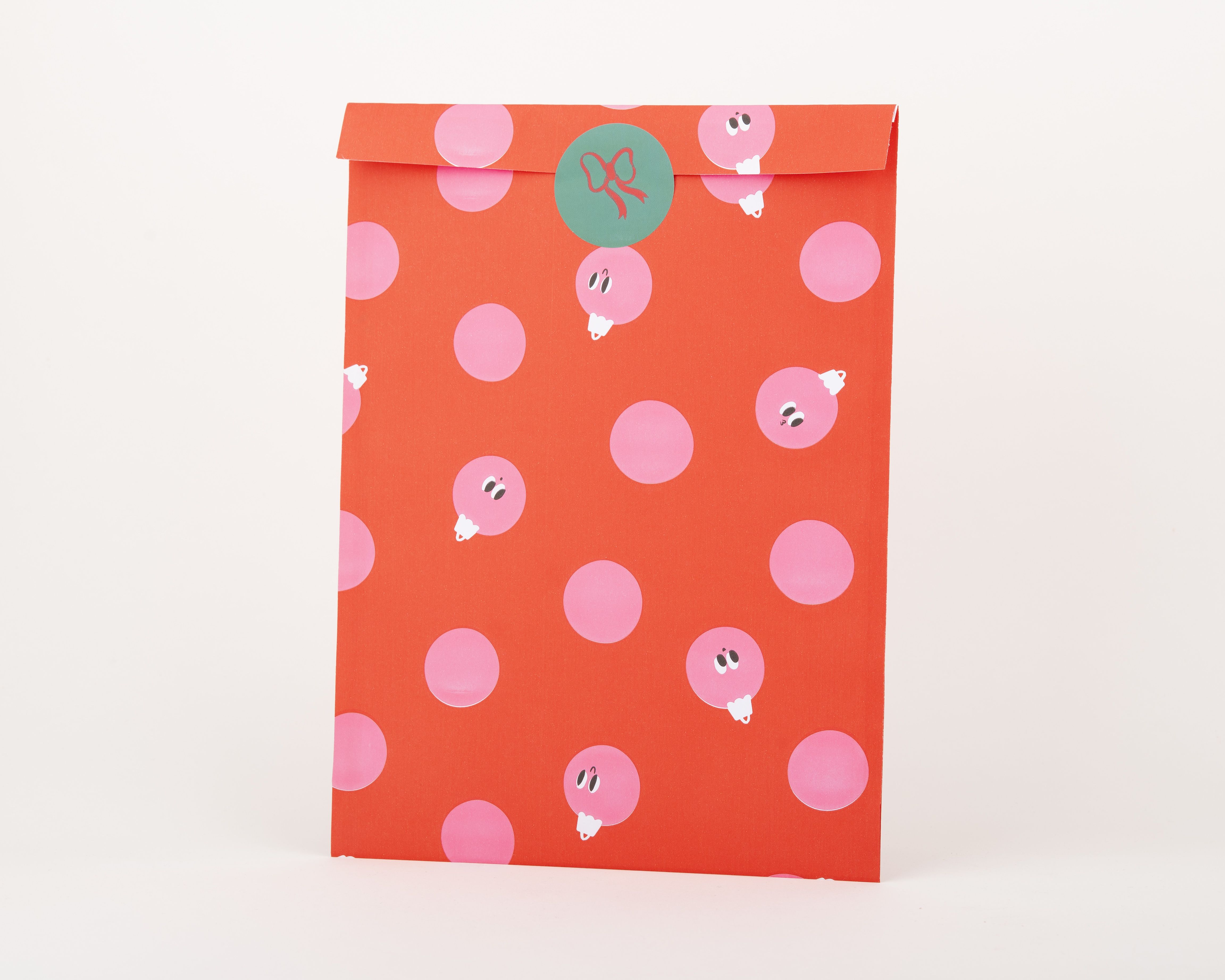 Papiertüten Flachbeutel in Rot mit pinkfarbenen Punkten, als Peek-a-Boo Baubles gestaltet Die Innenseite ist einfarbig rot