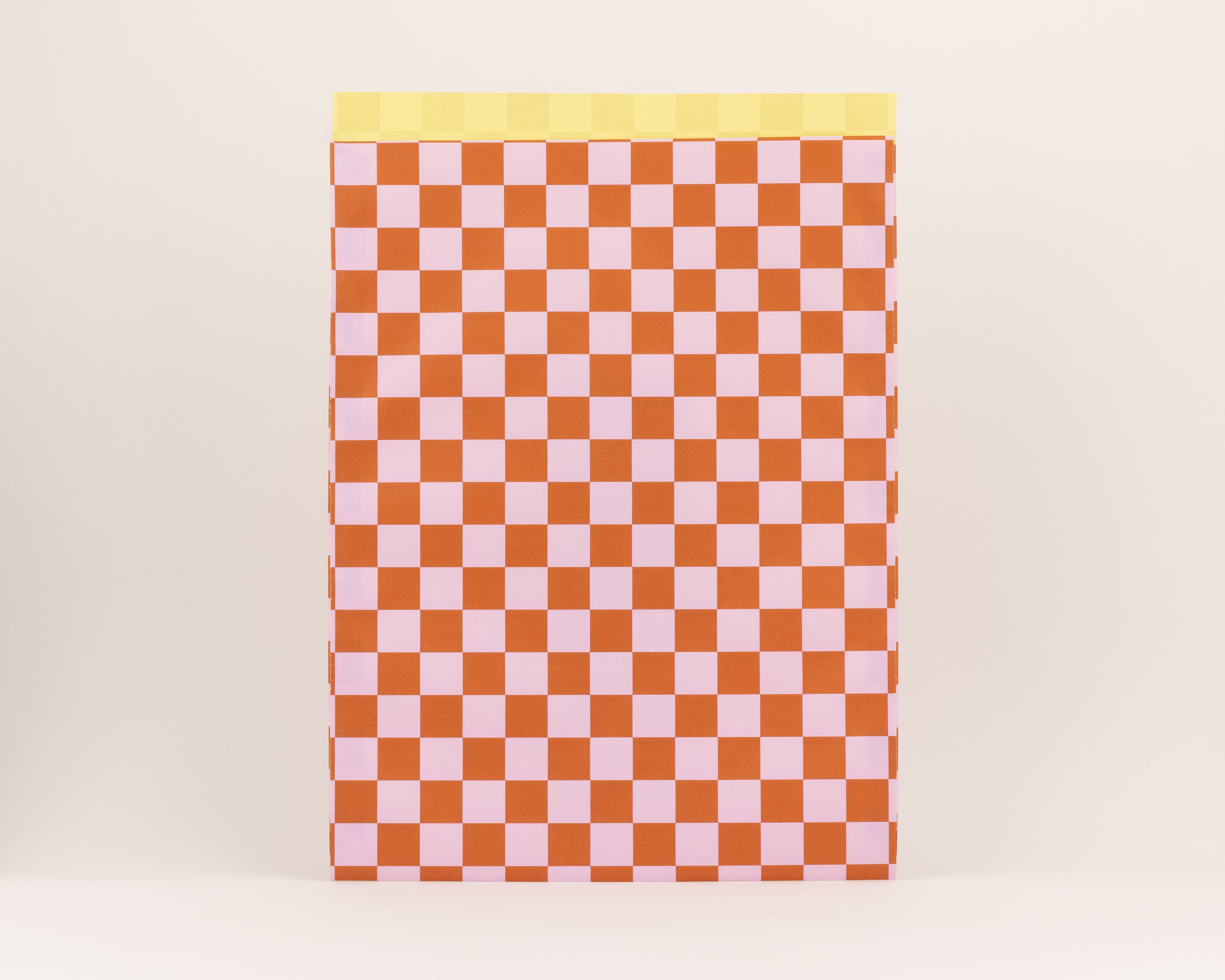 Flachbeutel mit Schachbrettmuster in Zimt und Rosa, die Innenseite ist in einem hellen Gelb gehalten