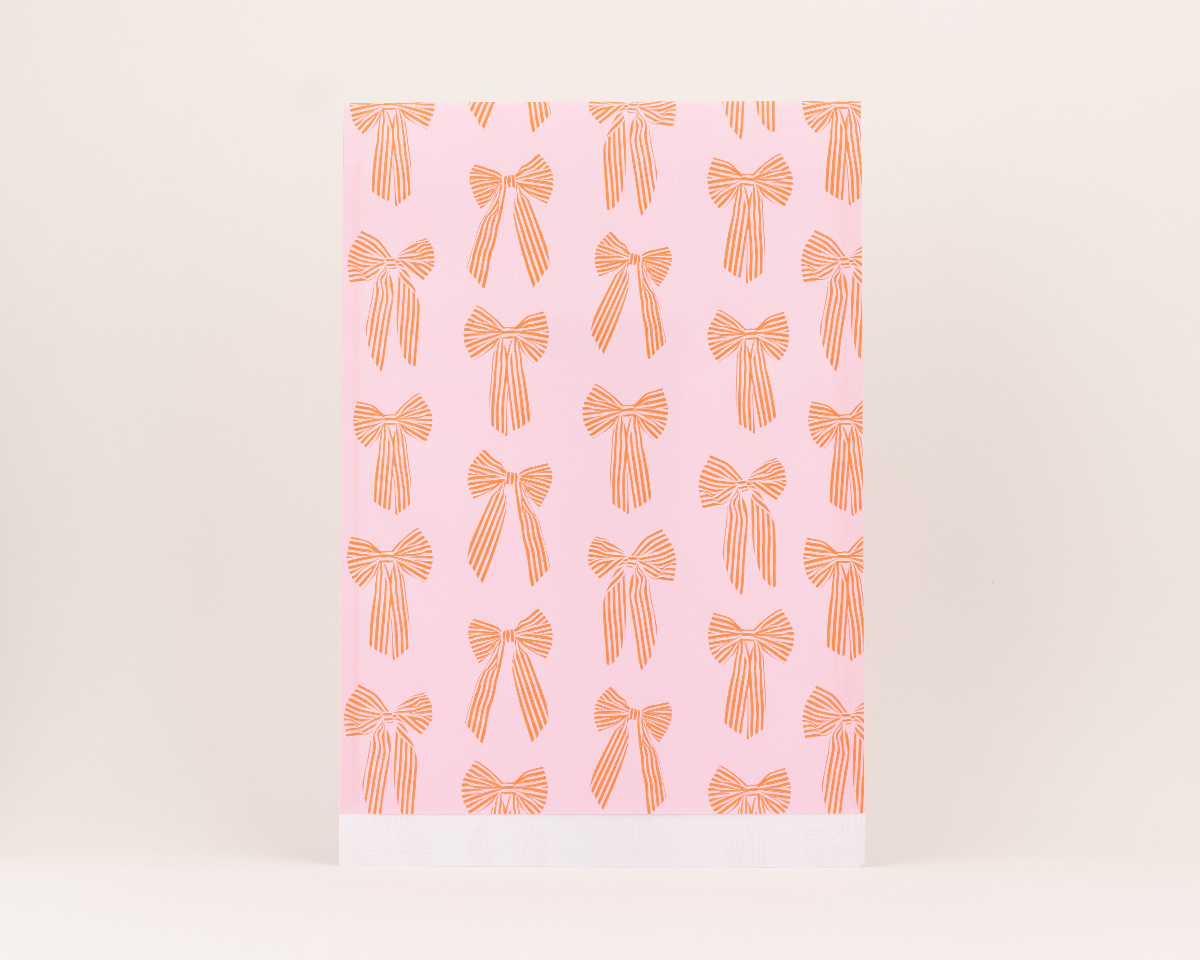 Flachbeutel mit einem rosa Hintergrund und einem Muster aus roten, gestreiften Schleifen, die Innenseite ist weiß