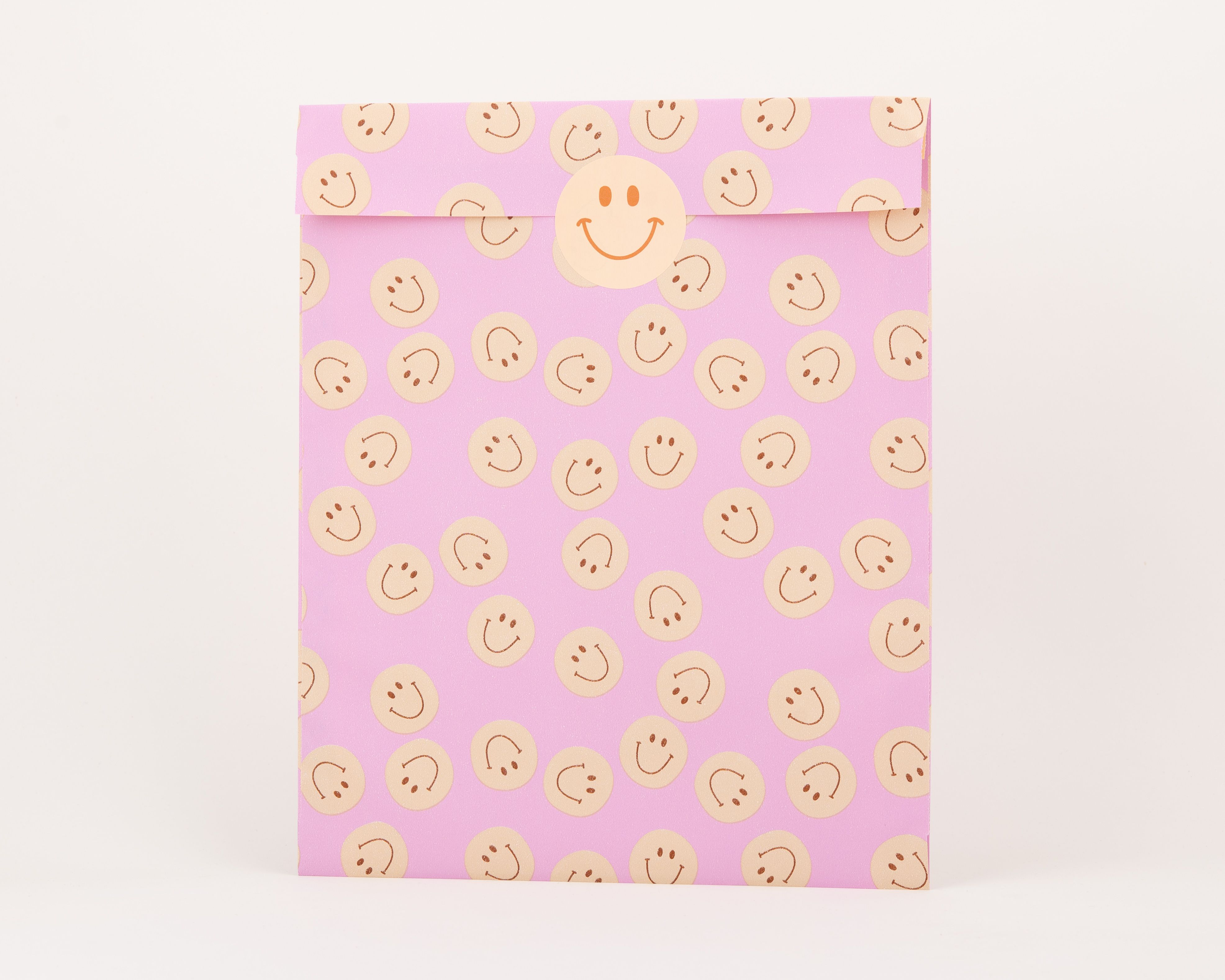Papiertüten Flachbeutel mit einem Muster aus hellorangen Smileys auf fliederfarbenem Hintergrund, die Innenseite ist passend gestaltet