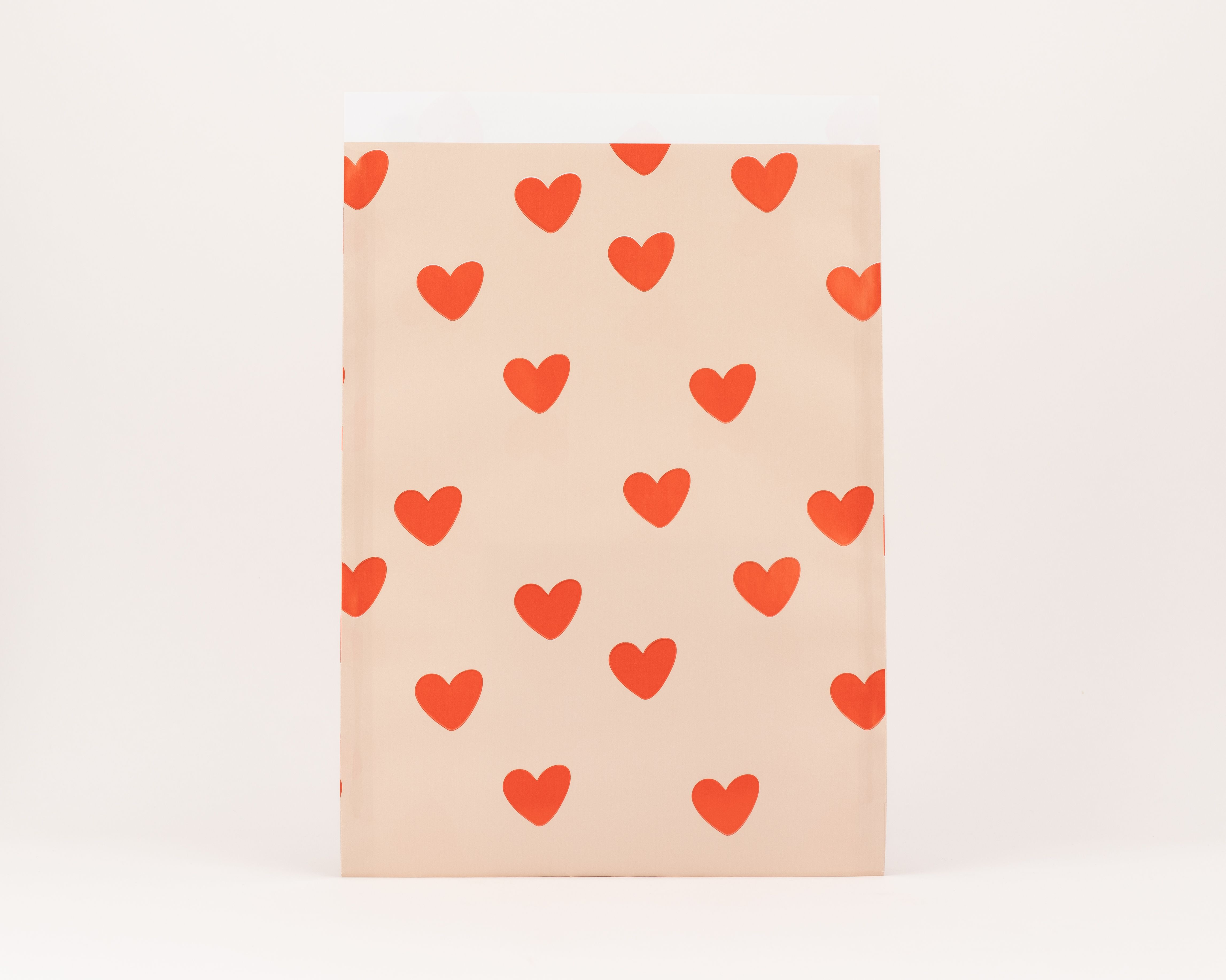 Flachbeutel mit beigem Grundton und roten Herzen, die Innenseite ist weiß