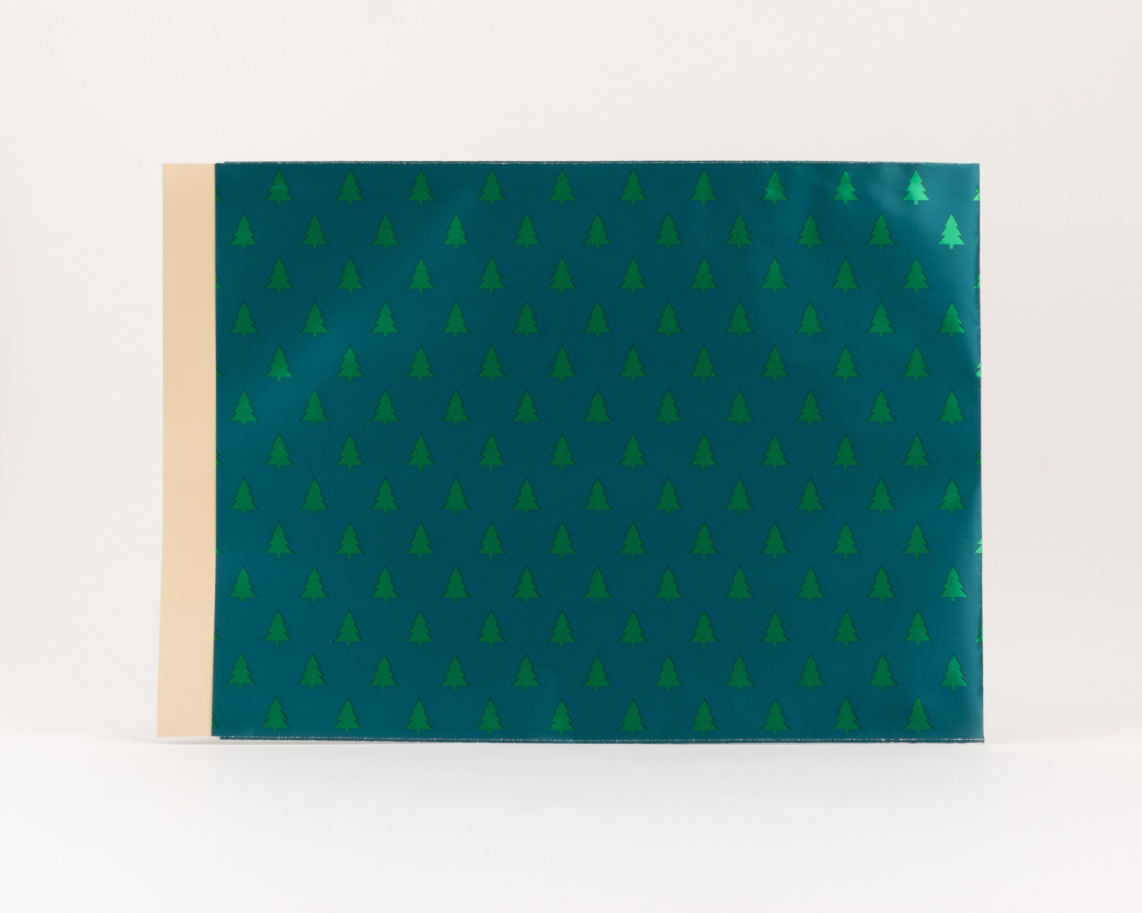 Flachbeutel mit grünem Tannenmuster und metallischem Schimmer auf der Außenseite, die Innenseite ist in Beige gehalten