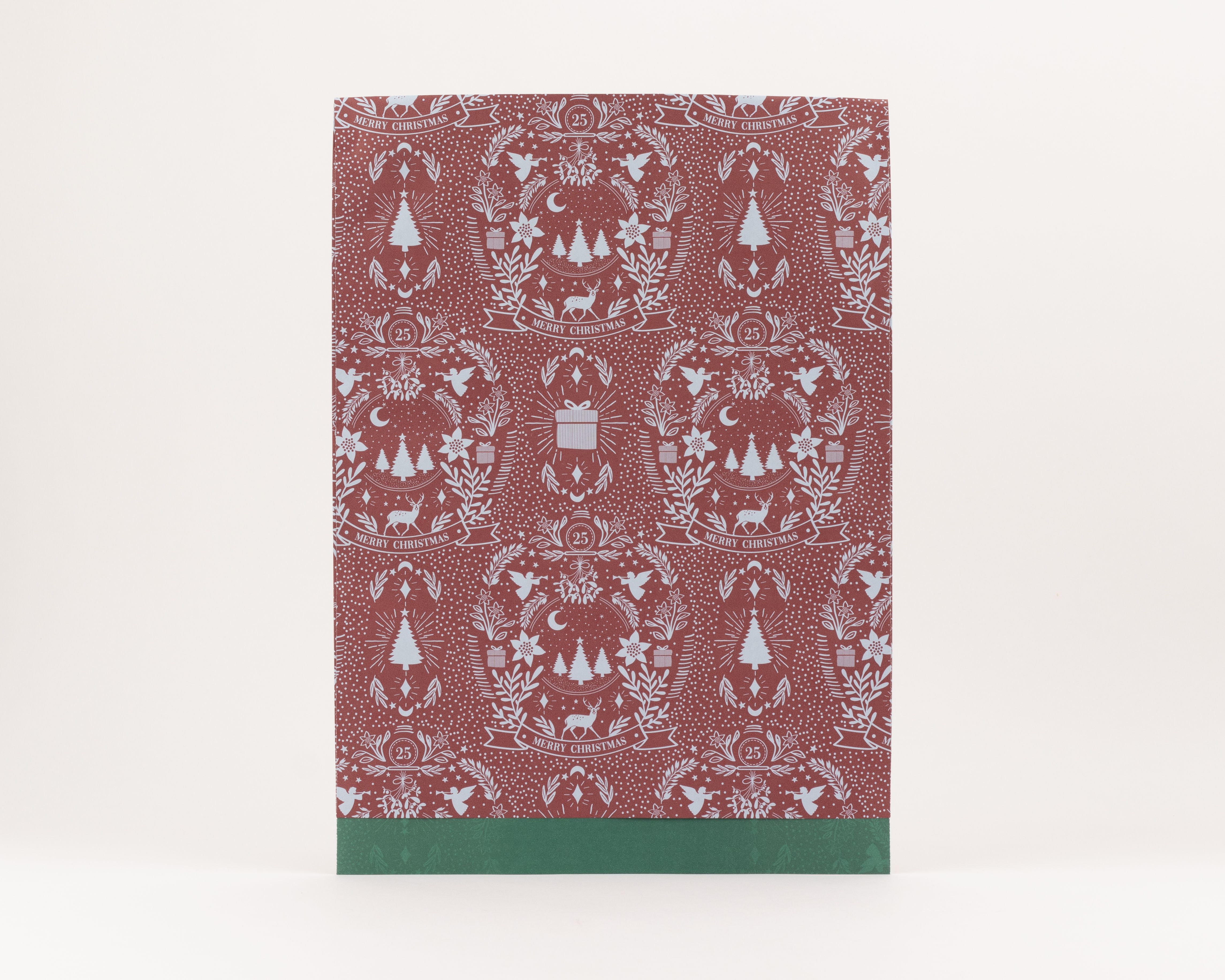 Flachbeutel in Burgunderrot mit blauem Vintage-Weihnachtsmuster, das Hirsche, Engel und Tannenbäume zeigt. Die Innenseite ist uni Grün.