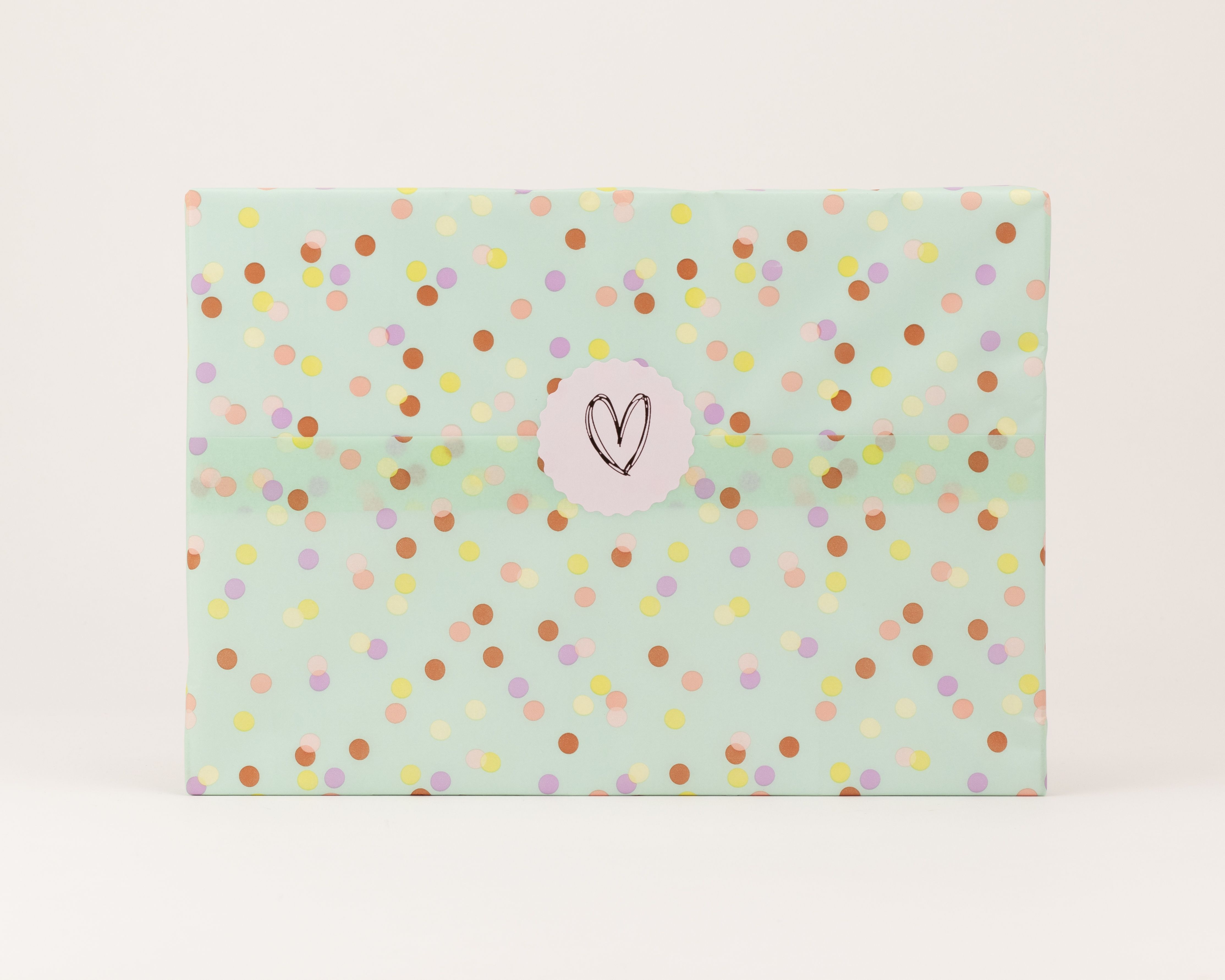 Seidenpapier in Mintgrün mit einem Konfettimuster in Gelb, Braun, Flieder und Lachsrosa