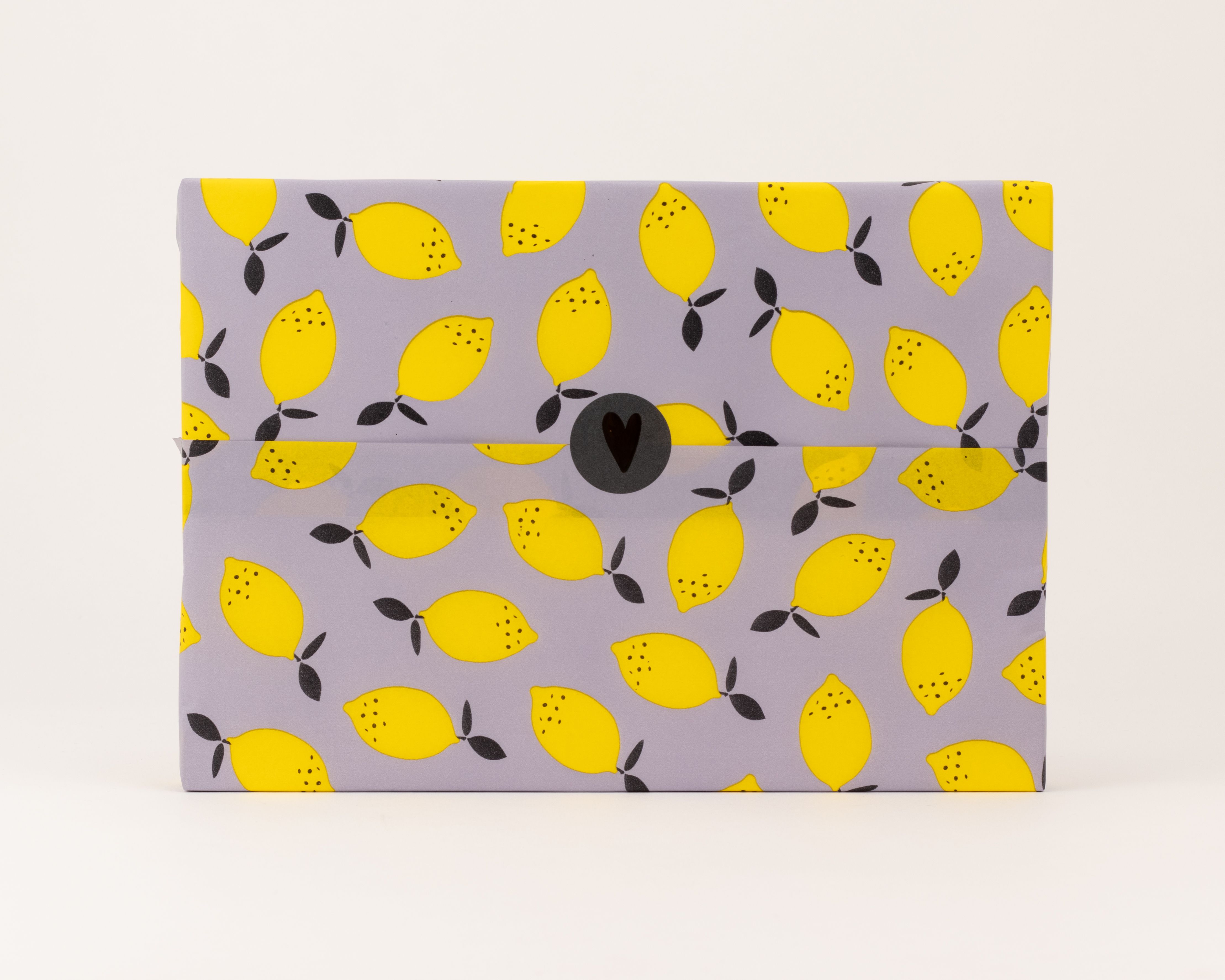 Seidenpapier mit einem Muster aus gelben Limonen und schwarzen Details auf lavendelfarbenem Hintergrund