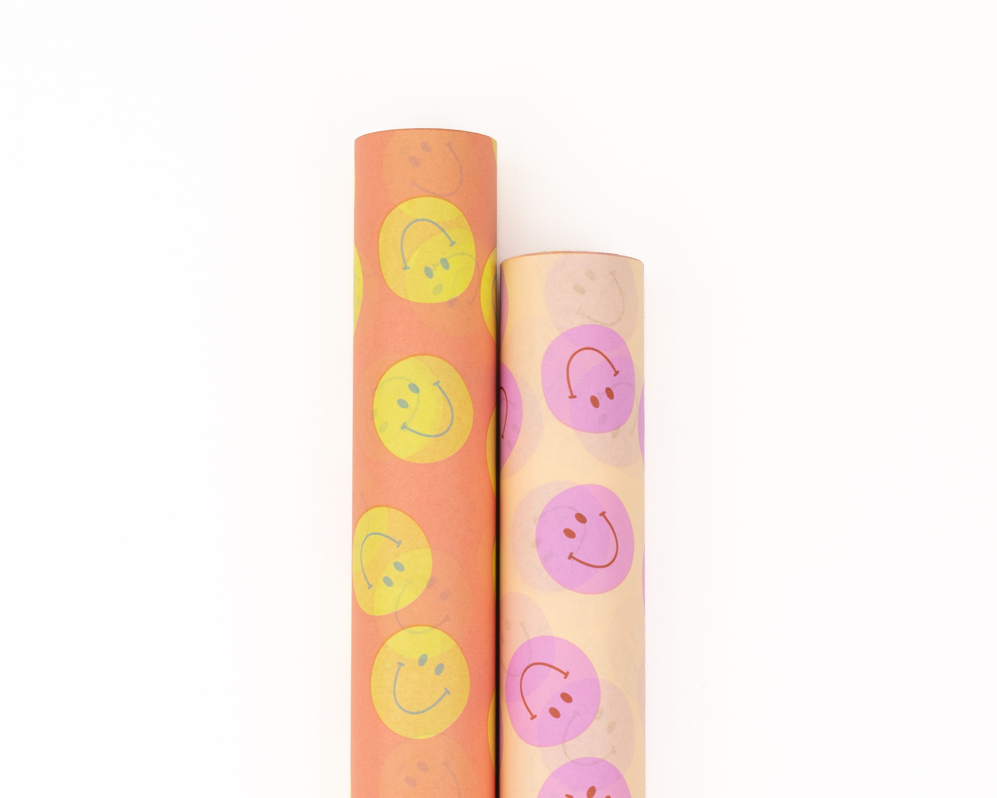 Geschenkpapier-Set mit zwei nebeneinander liegenden Rollen, bedruckt mit bunten Smiley-Mustern in Orange, Gelb, Pink und Creme