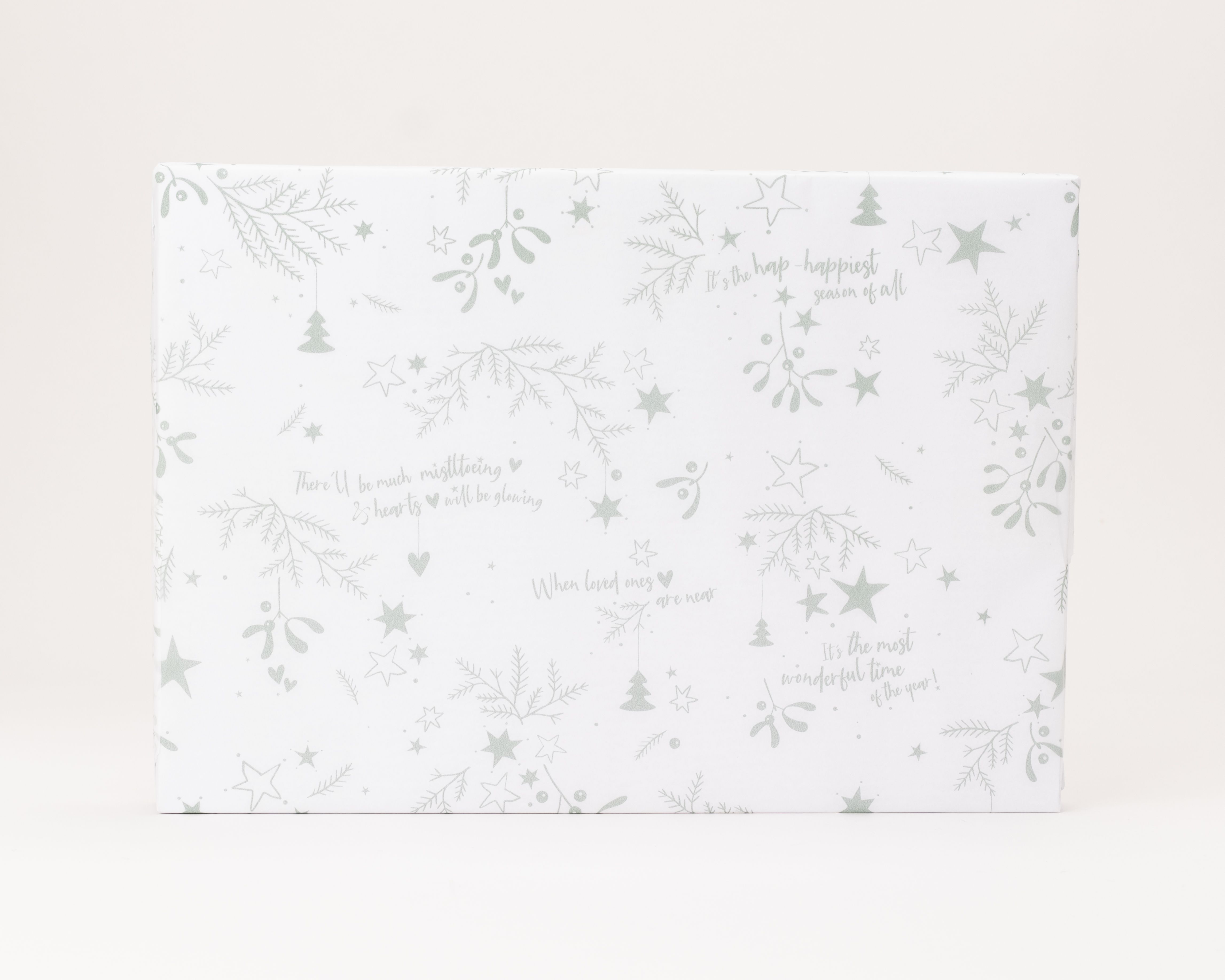 Seidenpapier in Weiß mit salbeigrünen weihnachtlichen Motiven wie Mistelzweigen, Sternen und kurzen englischen Zitaten