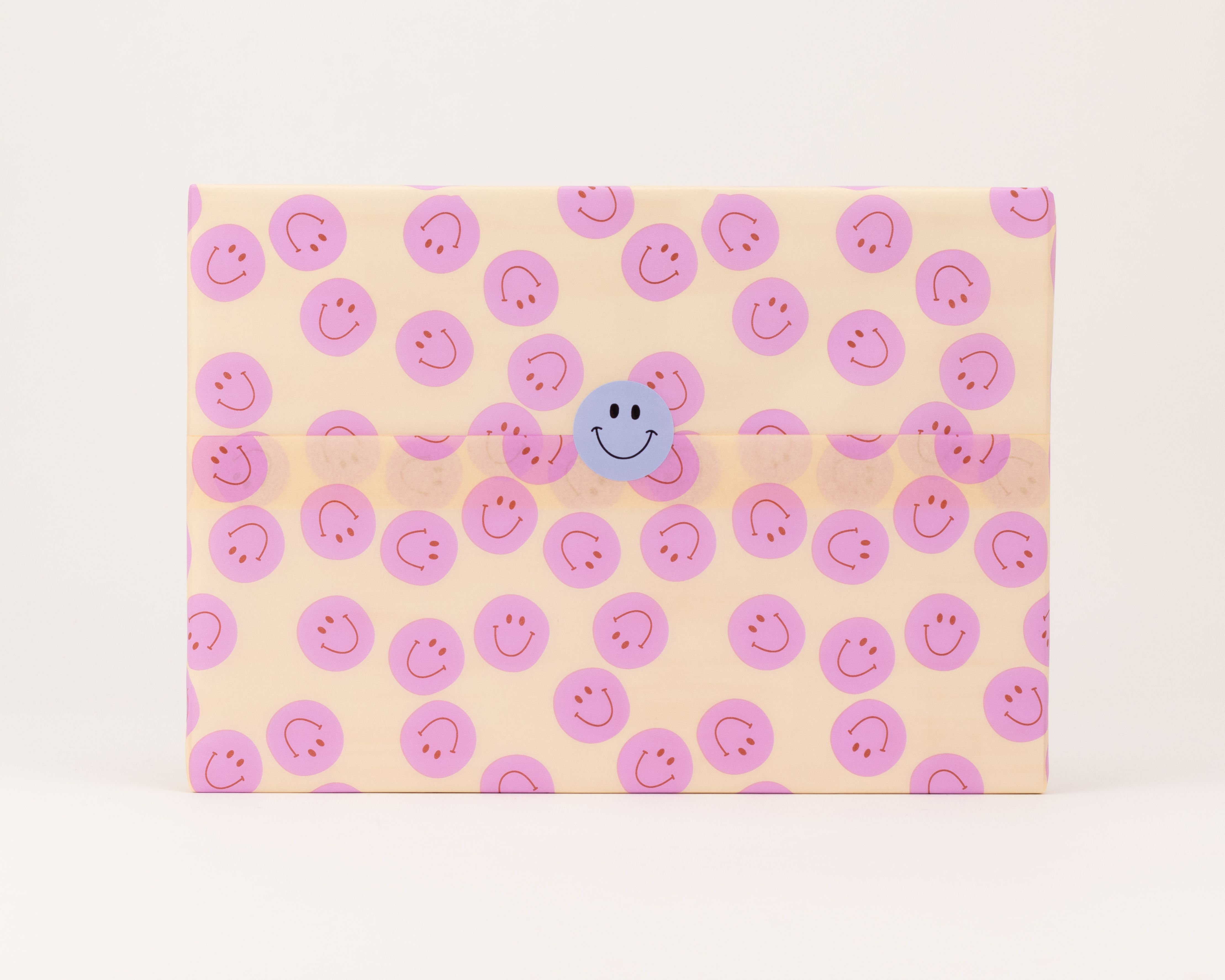 Seidenpapier in hellem Orange mit wiederkehrenden pinken Smiley-Gesichtern