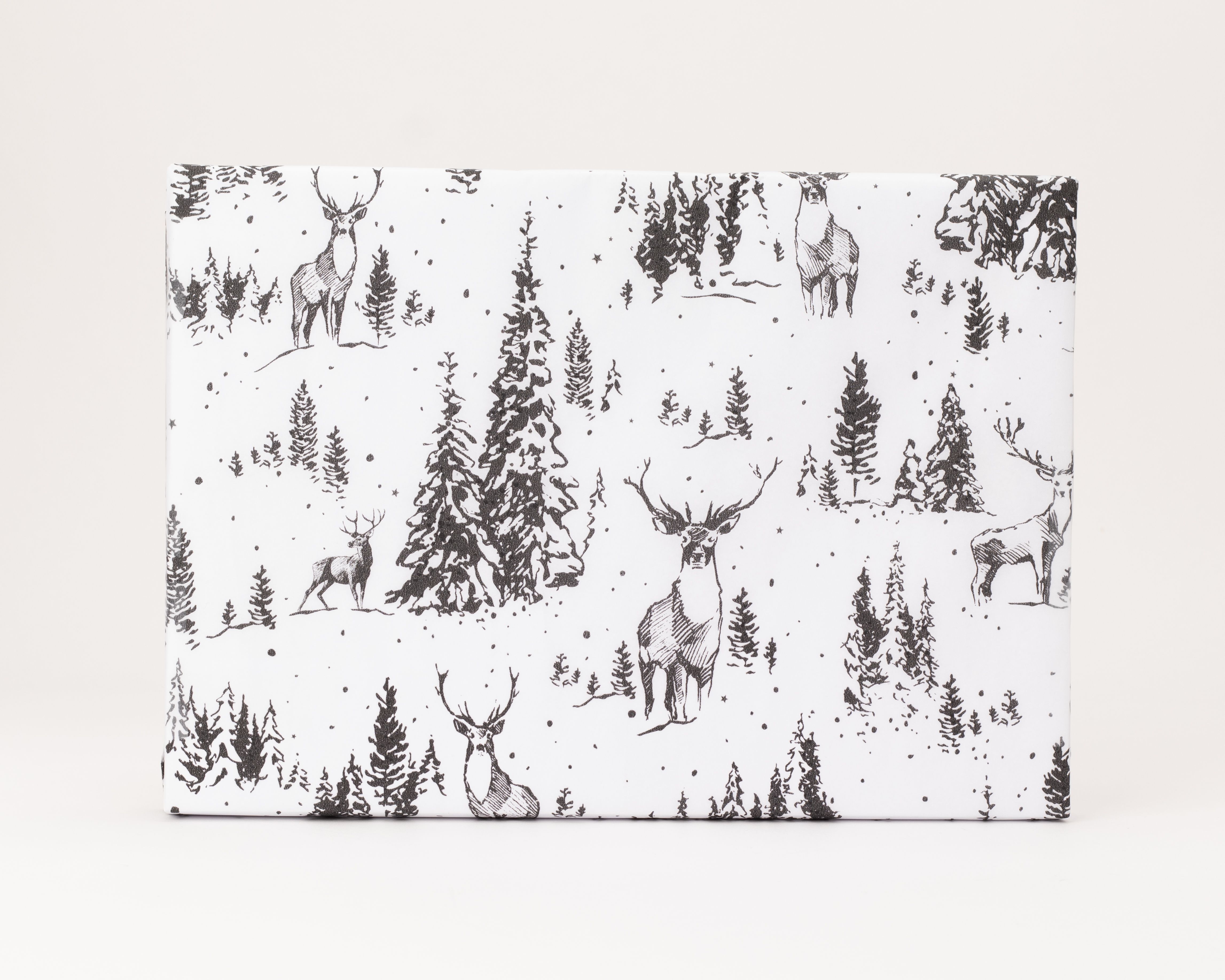 Seidenpapier mit einem detaillierten schwarz-weiß Muster, das einen Wald mit Hirschen und Tannenbäumen bei leichtem Schneefall zeigt
