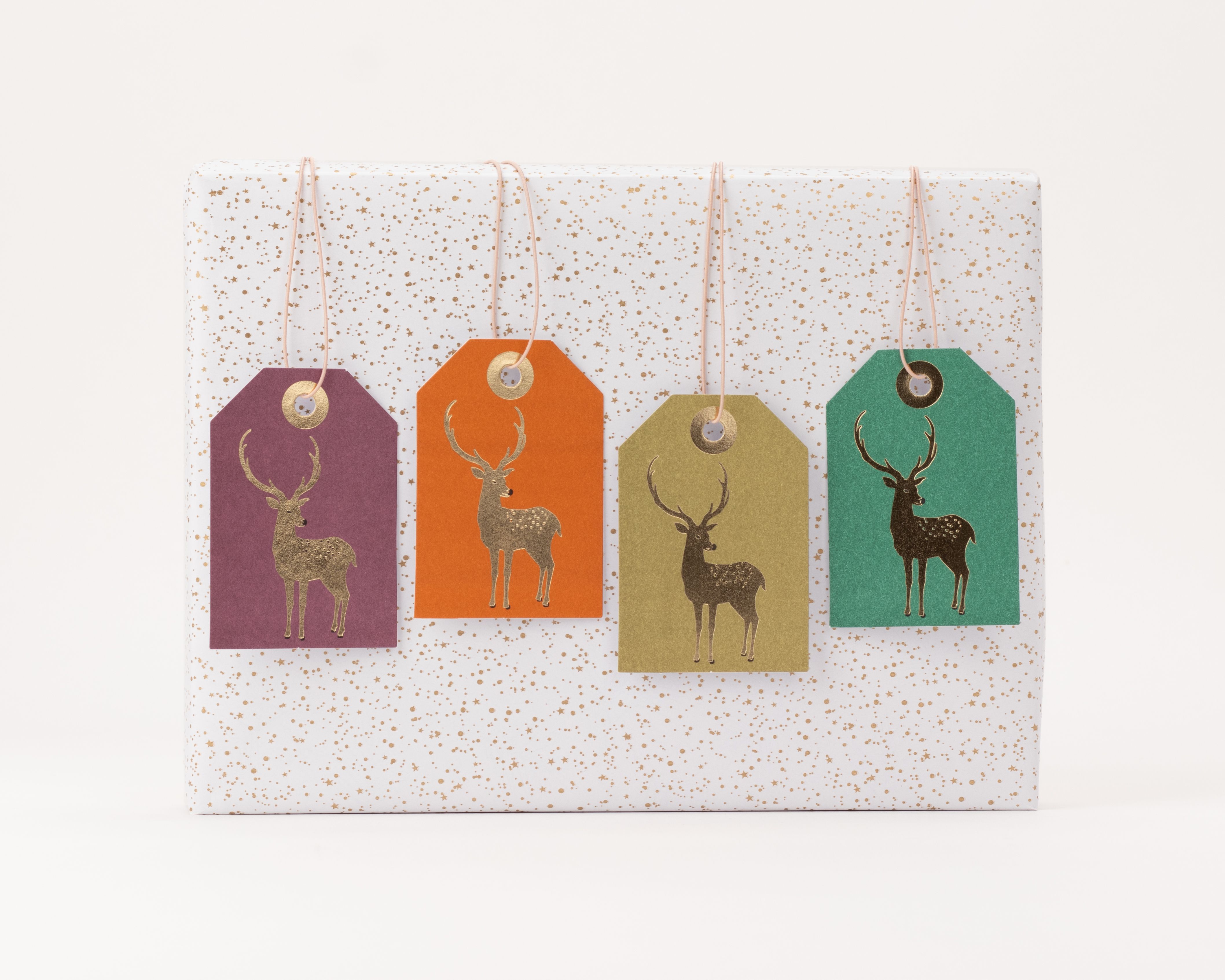 Geschenkanhänger-Set mit vier rechteckigen Anhängern in Lila, Orange, Olivgrün und Dunkelgrün, jeweils mit einem goldenen Hirschmotiv