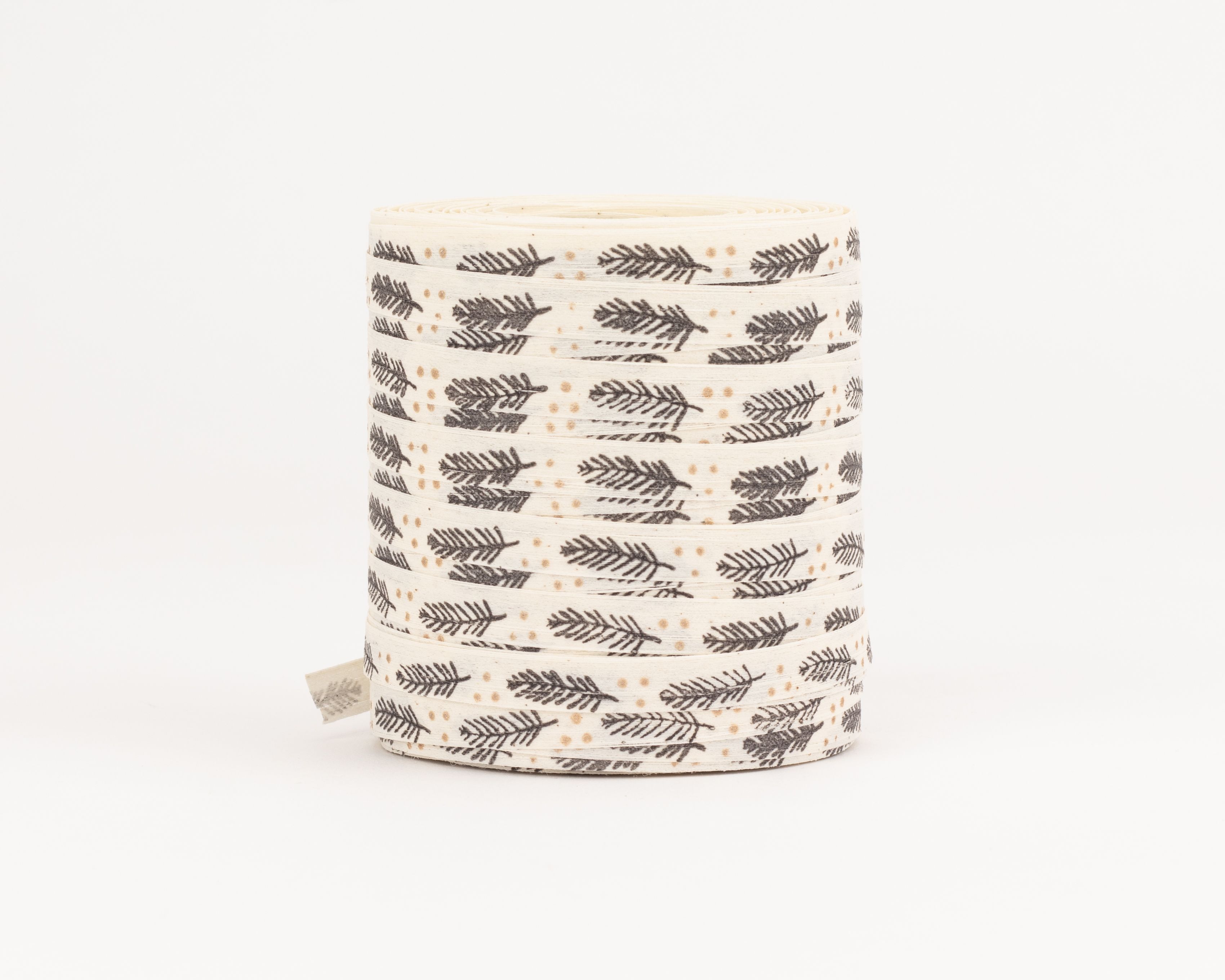 Geschenkband aus Stoff in Creme mit durchgehendem Muster aus grauen Tannenästen und kleinen goldenen Punkten