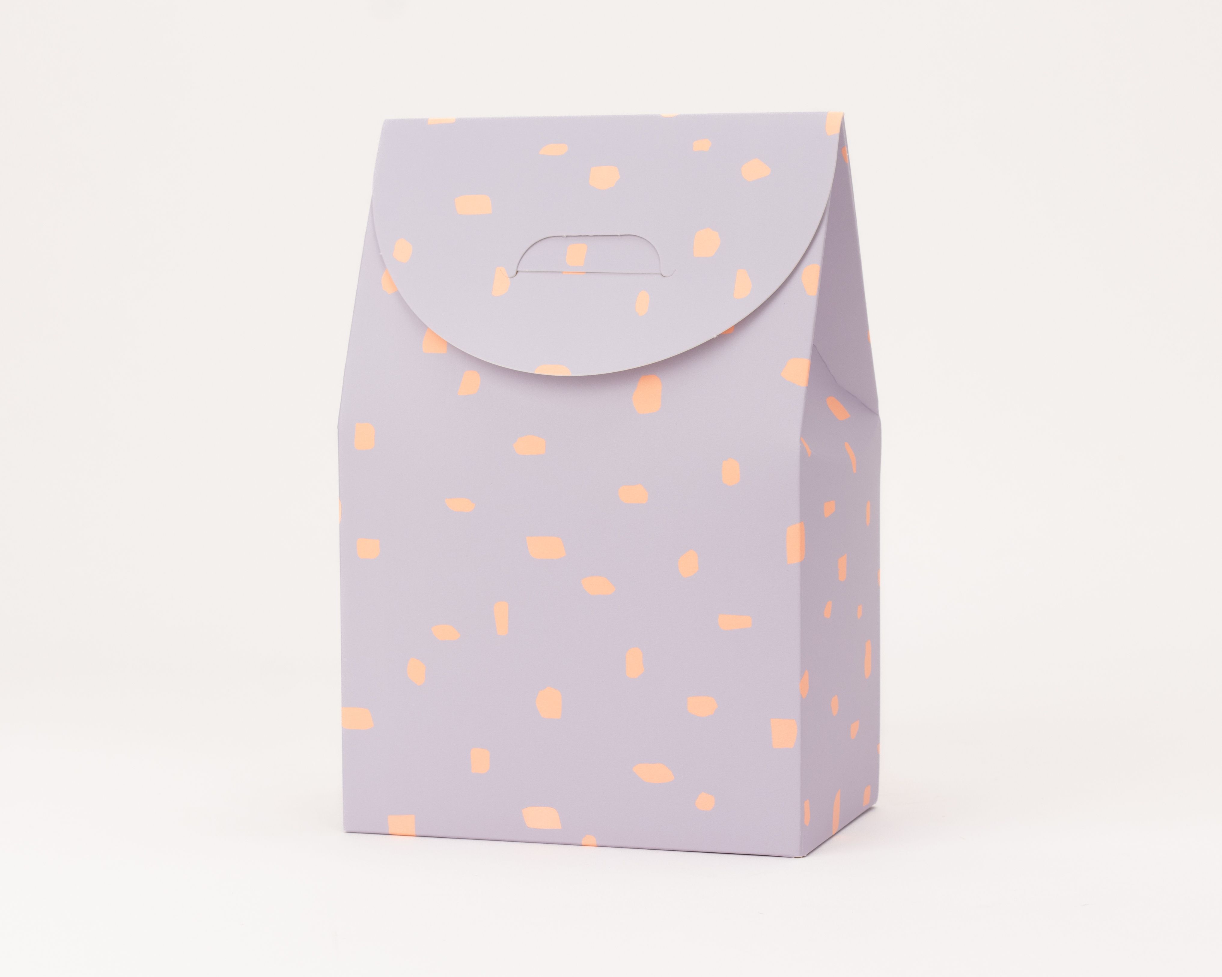 Geschenkboxen in Lila mit neonorangefarbenen Punkten und rechteckige Schachteln mit Deckelklappe