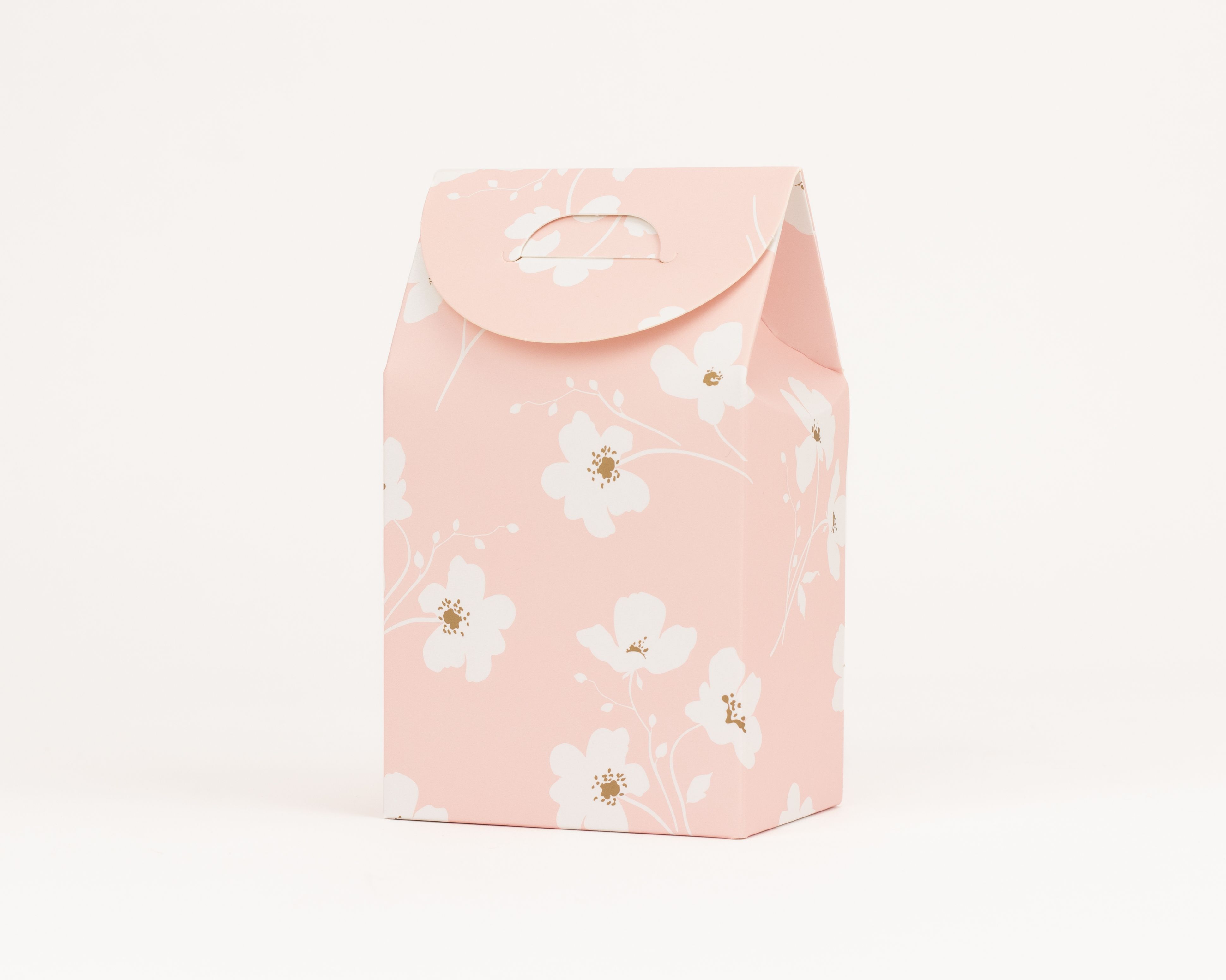 Geschenkboxen in Rosa mit floralem Wiesenblütenmuster aus weißen Blumen mit goldenen Kernen, ausgestattet mit einer integrierten Grifföffnung